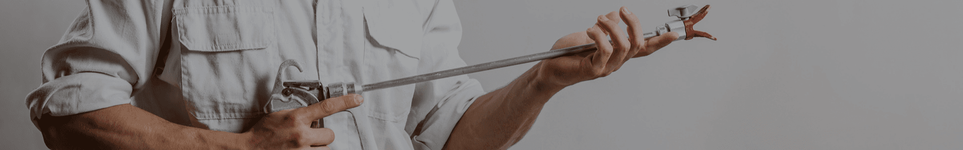Professional holding a GROG airless spray gun extension